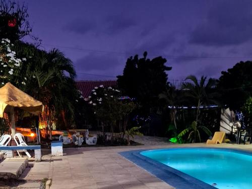 a swimming pool in a resort at night at Casa do Galego no Residência Família in Canoa Quebrada