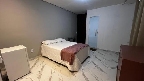 um quarto com uma cama e piso em mármore em Flat no Centro da Cidade em Parauapebas