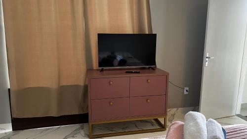 uma cómoda com uma televisão em cima em Flat no Centro da Cidade em Parauapebas