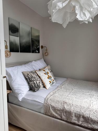 a bed with two pillows on it in a bedroom at Apartament Cicha Przystań w centrum Zakopanego APARTZAKOP in Zakopane