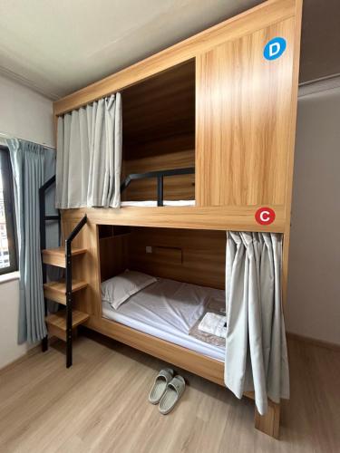 Litera de madera grande en una habitación en Comfy Hotels Share Bathroom คอมฟี่ โฮเทล ห้องน้ำรวม ซอยกิ่งแก้ว 31ก, en Samutprakarn