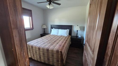 a bedroom with a bed and a ceiling fan at Chalets l'Acadien sur mer in Petit Rocher