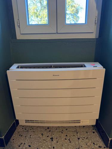 un termosifone in una stanza blu con due finestre di Maison traditionnelle avec vues sur St Michel a Murato