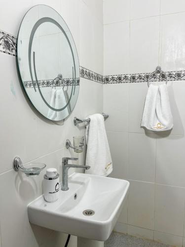 ein weißes Badezimmer mit Waschbecken und Spiegel in der Unterkunft Palais Taroudant in Taroudant