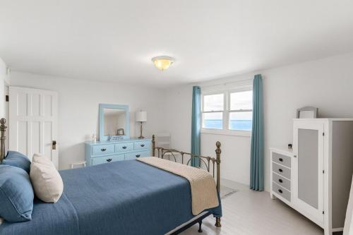 een slaapkamer met een blauw bed en een spiegel bij Crystal Beach Stunning Waterfront Stay with Fire Pit in Fort Erie