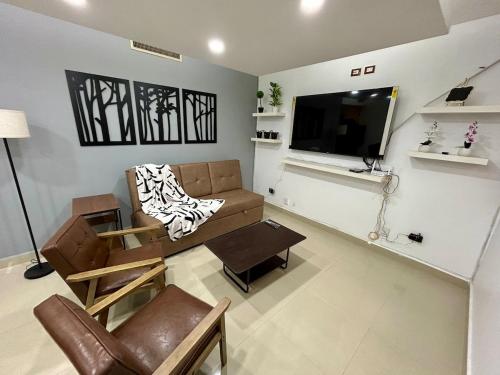 a living room with a couch and a flat screen tv at Punta Rocosa in Torreón