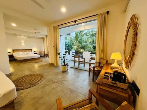 a bedroom with a bed and a living room at OLA Tangalle in Tangalle