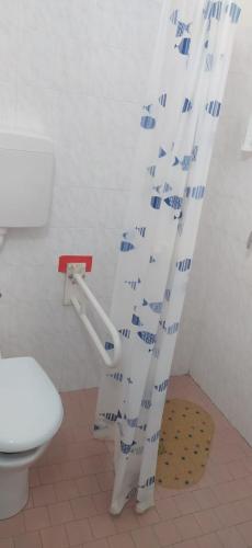 a bathroom with a toilet and a shower curtain at Hotel Orchidea Rimini in Rimini
