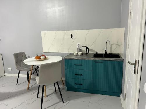 Bekarys Hotel في أستانا: مطبخ مع حوض وطاولة وكراسي