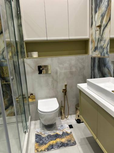 a bathroom with a toilet and a shower and a sink at NestOne - Apartment hotels in Tashkent