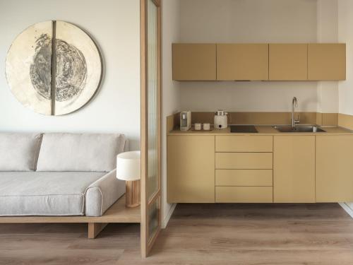 Kaoma Comfort Suites في تريكالا: غرفة معيشة مع أريكة ومطبخ