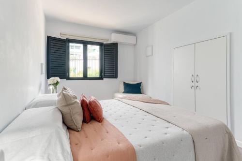 two beds in a bedroom with white walls and a window at Casa Tabera - Sun Club Playa del Águila in Playa del Aguila