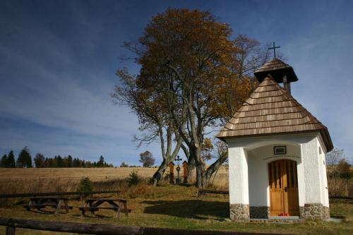 a small chapel with a cross on top of it at U jezera Laka in Prášily