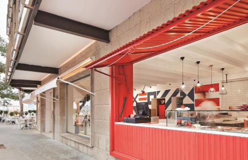 a restaurant with a red facade and a counter at Hotel Eolo in Port de Pollensa