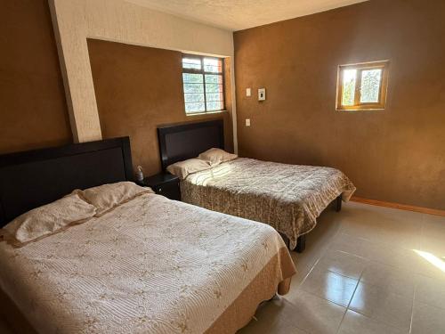 a hotel room with two beds and two windows at Casa Terral in Balastre Rojo