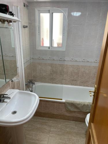 a bathroom with a sink and a bath tub at Amarillo Apartment in Puerto de Mazarrón