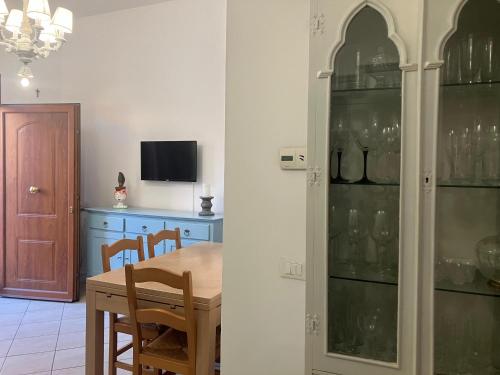 una sala da pranzo con tavolo e mobile con bicchieri da vino di A casa di Greta a Prato