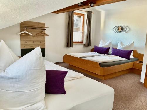 een hotelkamer met 2 bedden en paarse kussens bij Ferienwohnung Vesna & Alex in Elmen