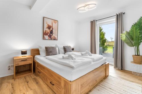 a bedroom with a large bed with white sheets at TM Stays - NIVIS - Gemütliches Apartment mit Terrasse & Garten - Ruhe, Natur, Wandern, Ski in Medebach