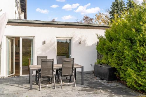 a patio with a table and chairs in front of a house at TM Stays - NIVIS - Gemütliches Apartment mit Terrasse & Garten - Ruhe, Natur, Wandern, Ski in Medebach