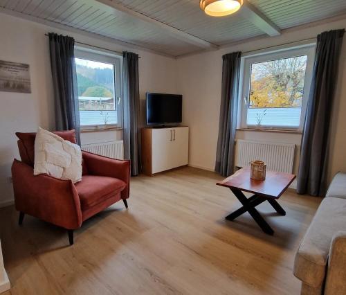 a living room with a couch and a chair and a table at Ferienwohnung Gartenblick in Eslohe