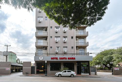 a white car parked in front of a building at Hotel Santa Maria by RB Hotelaria in Campo Mourão