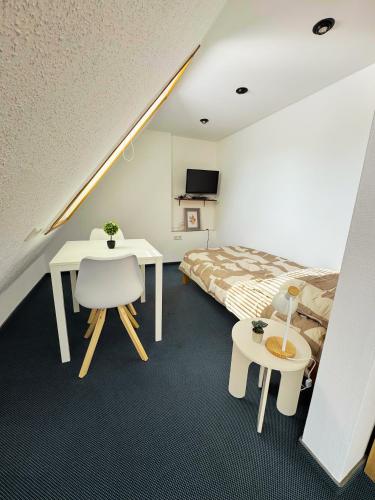 a bedroom with a bed and a desk and a table at die GastHütte in Eisenhüttenstadt