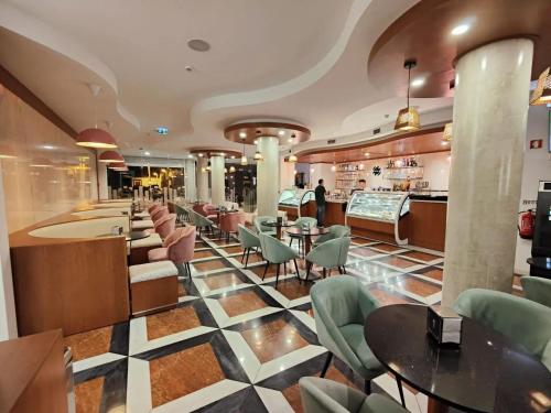 a restaurant with tables and chairs and a bar at Lazy Days - Adults Only - Duna Parque Group in Vila Nova de Milfontes