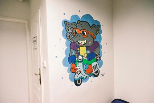 a painting of a cat on a motorcycle on a wall at Mild Elephants Hostel in Bratislava