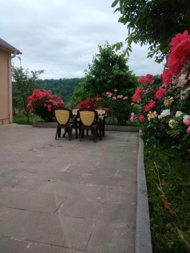 un patio con tavolo, sedie e fiori di House Guest a Qusar