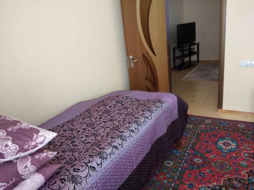 una camera da letto con un letto viola e una porta di House Guest a Qusar