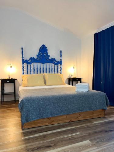 a bedroom with a large bed with a blue headboard at JUNKEIRA - Casa, Douro e Campo