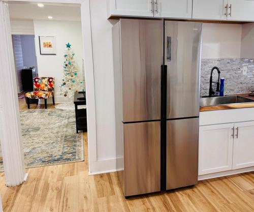 a stainless steel refrigerator in a kitchen with a christmas tree at Perfect staycation in Ohio City, walk to W 25 st in Cleveland