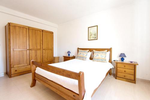 una camera da letto con un letto grande e un armadio in legno di Vila Apartment - Duna Parque Resorts & Hotels a Vila Nova de Milfontes
