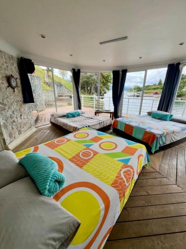 Chalet Lago Calima - Piscina Natural y Jacuzzi في كاليما: سريرين يجلسون في غرفة مع نوافذ