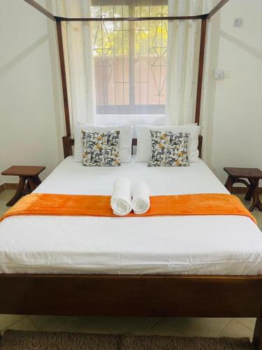 a bed with two white shoes sitting on top of it at Marina Villa in Mombasa