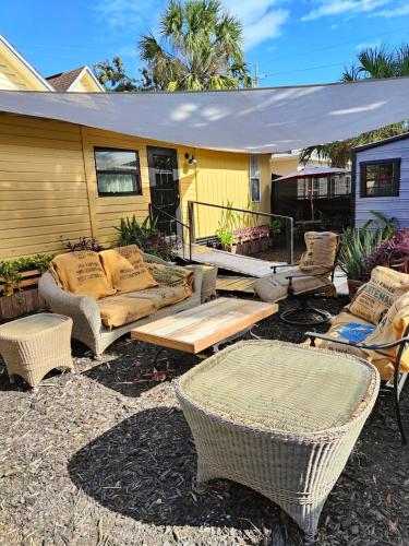 a patio with wicker chairs and tables in front of a house at Palm Villa Hostel in Tampa