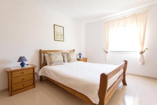 a bedroom with a bed and a window at Vila Apartment - Duna Parque Group in Vila Nova de Milfontes