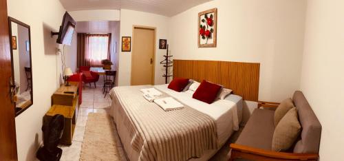 a hotel room with a bed and a couch at Hospedaria Vila Rica - Pousada a 1 km do Centro Histórico in Ouro Preto