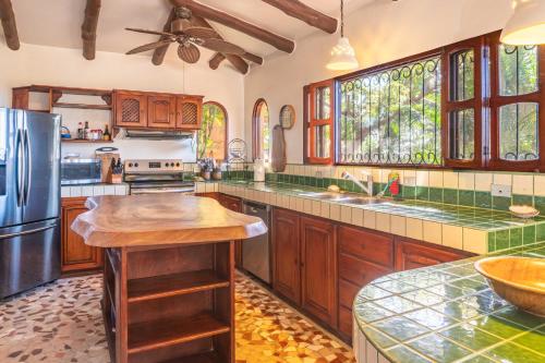 a kitchen with wooden cabinets and a stainless steel refrigerator at Casa Sonora - Ocean View in Carrillo