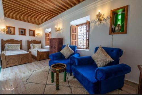 a living room with blue couches and a bed at Dar Chama in Chefchaouene