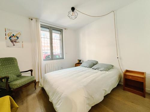 ein Schlafzimmer mit einem weißen Bett und einem Stuhl in der Unterkunft Loft Évasion aux Portes de Paris in Bagnolet