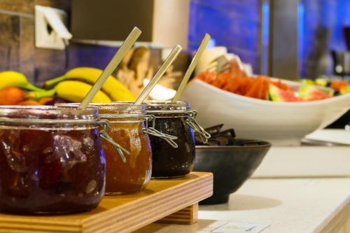 two jars of jam and a bowl of fruit at SEETELHOTEL Kaiserstrand Beachhotel das Lifestyle-Hotel direkt am Strand in Bansin