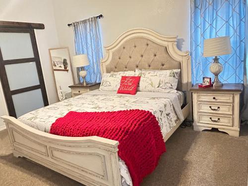 a bedroom with a white bed with a red blanket at My house your house in Fort Smith