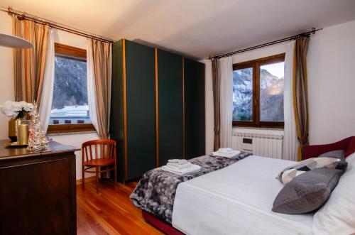 VivimiHome - Rifugio Genzianella في سان دومينيكو: غرفة نوم بسرير ومكتب ونوافذ