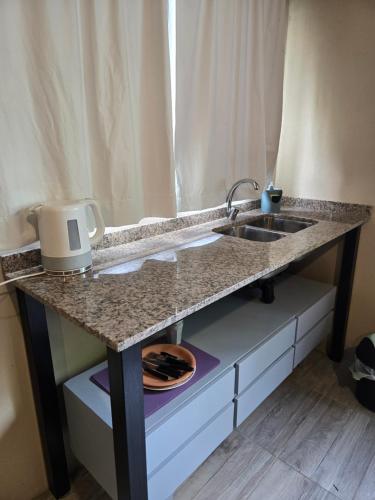 una encimera de cocina con fregadero en una habitación en La Tata, en Veronica