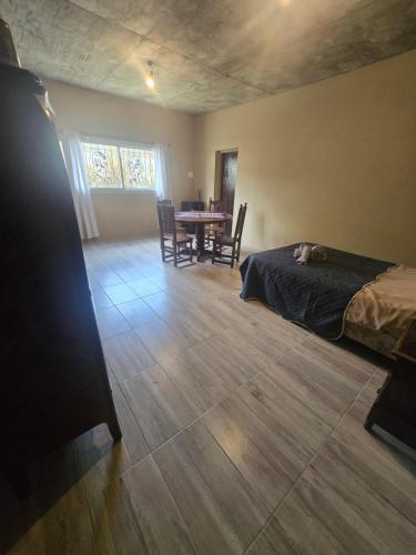 Un dormitorio con una cama y una mesa con sillas. en La Tata, en Veronica