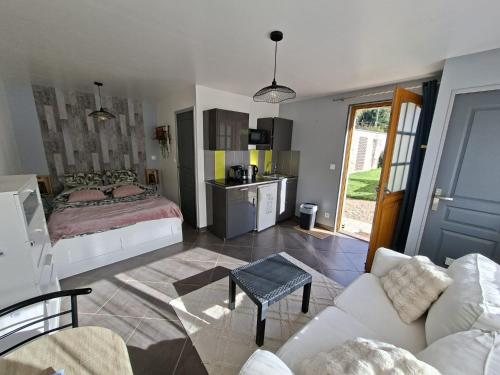 a living room with a bed and a couch at Studio Cozy in La Celle-sous-Gouzon
