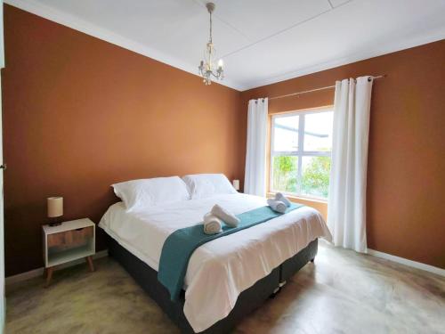 The Fifth Tee Villa في Stompneusbaai: غرفة نوم بسرير كبير مع نافذة