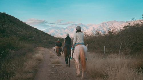 卡布拉科拉尔Sentio Camps的一群人骑着马沿着土路行驶